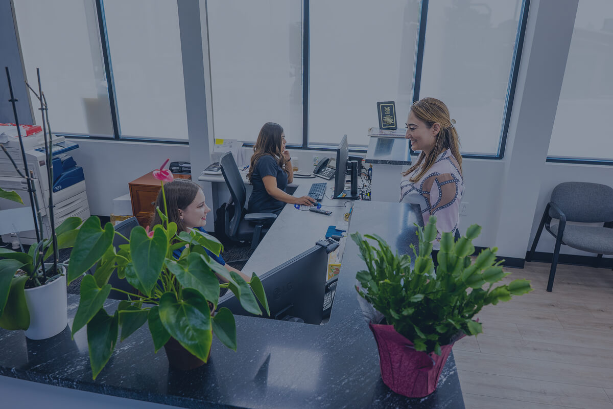 Image of a young patient checking in at the front desk of Diamond Dental Group in Denver CO.