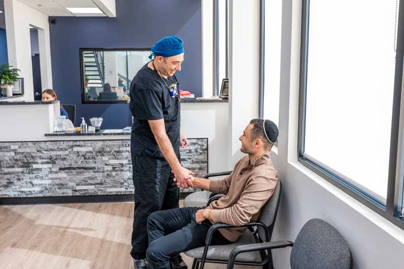 Patient shaking hands with Dr. Alexander Katanov, DMD at Diamond Dental Group in Denver CO.