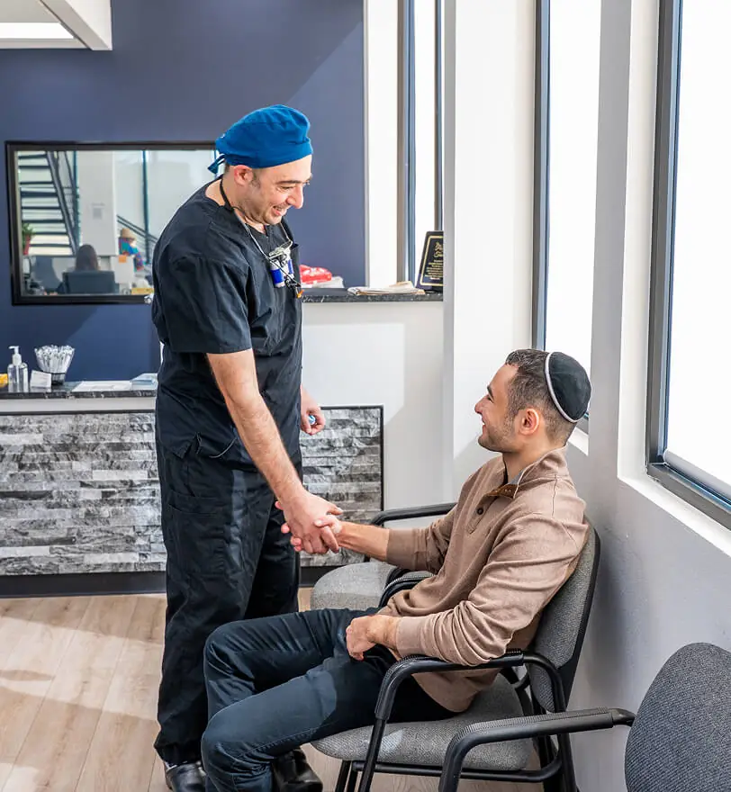 Image of Dr. Alexander Katanov, DMD shaking the hand of a patient at the office of Diamond Dental Group in Denver CO.