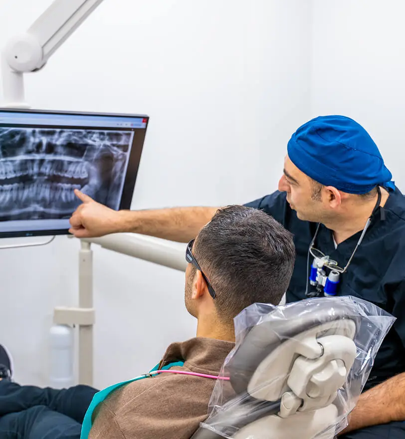 Image of Dr. Alexander Katanov, DMD pointing at an X-Ray while speaking to a patient at the office of Diamond Dental Group in Denver CO.